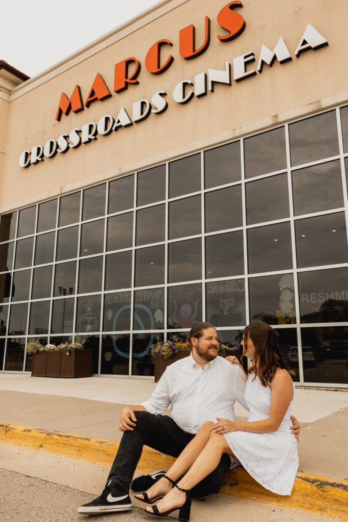 Man and women sitting outside of Waterloo, Iowa movie theater. 