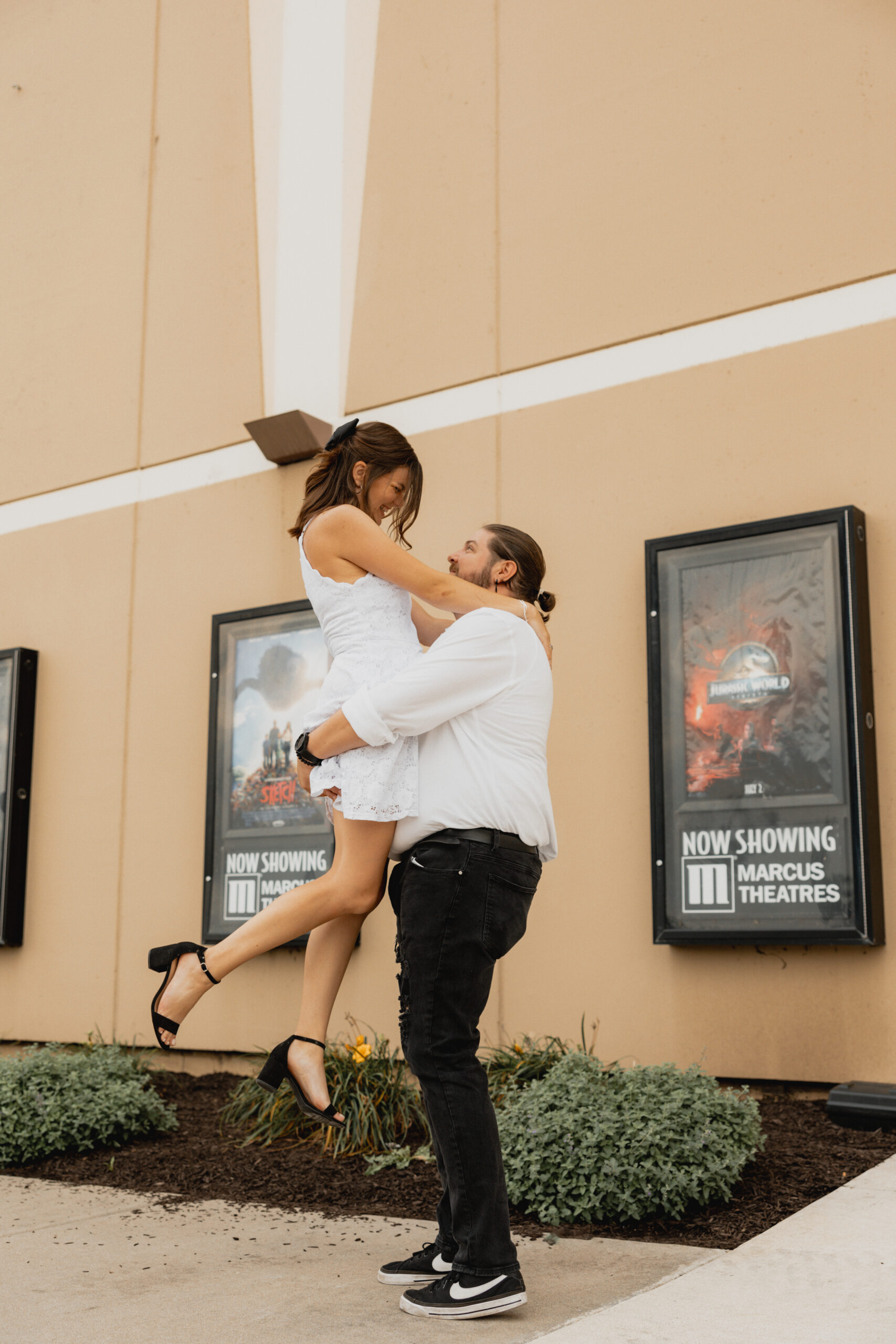 Man and Women hugging outside movie theater.